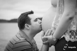 pai beijando a barriga da esposa gestante em ensaio fotografico