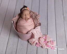 foto bebê recem nascido em um baldinho com wrap e flores