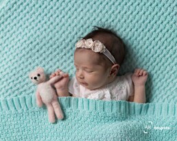 foto recem nascido em curitiba, bebê segurando um ursinho rosa