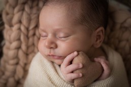 ensaio newborn bebe enrolado no wrap segurando coração