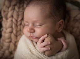 ensaio newborn bebe enrolado no wrap segurando coração