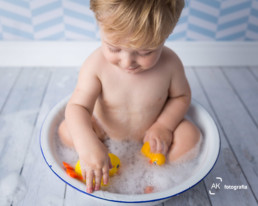 bebê tomando banho com patinhos de borracha