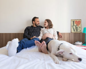 casal gestante na cama com o cachorro